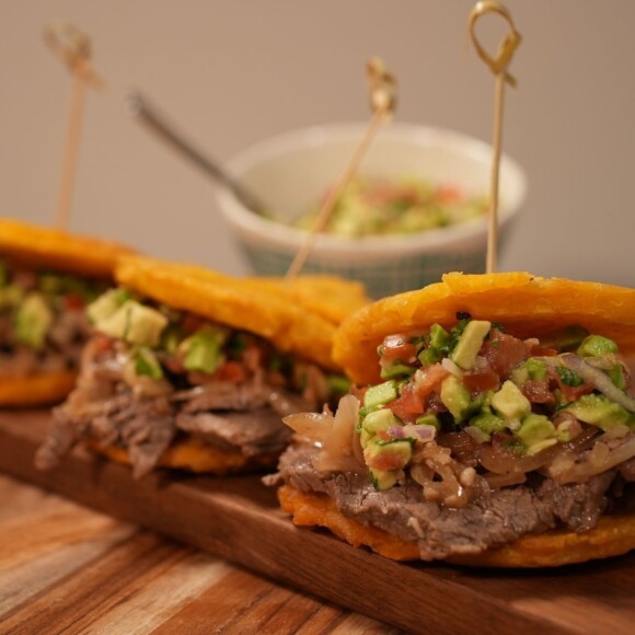 Sandwich de Tostones de Bistec Encebollado con Salsa